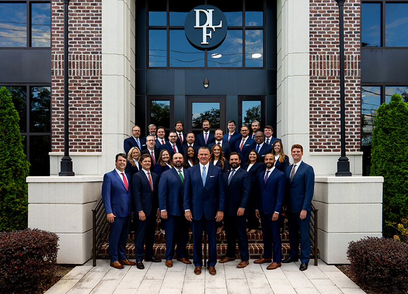 Derrick Law Firm team in front of the office building